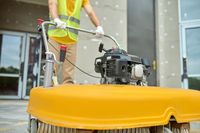 workman-applying-road-sweeper-construction-site